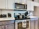 Stainless steel appliances and dark gray cabinets in condo kitchen at 7664 Comrow St # 301, Kissimmee, FL 34747