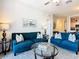 Living area with two blue sofas and a glass coffee table at 7664 Comrow St # 301, Kissimmee, FL 34747