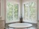 Relaxing bathroom featuring a corner soaking tub and plantation shutters at 10110 Royal Island Ct, Orlando, FL 32836