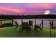 Evening view of a waterfront deck with seating, overlooking a lake with fireworks at 10110 Royal Island Ct, Orlando, FL 32836