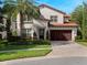 Two-story house with a brown garage door and manicured landscaping at 10110 Royal Island Ct, Orlando, FL 32836