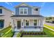 Two-story house with gray and blue siding, stone accents, and a front porch at 11024 Folklore Street, Winter Garden, FL 34787