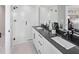 Modern bathroom boasts double vanity with dark countertop and a walk-in shower at 12439 Shipwatch St, Orlando, FL 32832