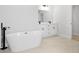 Modern bathroom featuring a soaking tub, dual vanity with black fixtures and stone countertops at 15033 Sw 35Th Cir, Ocala, FL 34473