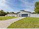 Modern home featuring a gray exterior, a blue garage door, and a well-manicured lawn and concrete driveway at 15033 Sw 35Th Cir, Ocala, FL 34473