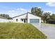 Newly constructed home with a gray exterior, dark gray garage door, and a well-maintained lawn at 15033 Sw 35Th Cir, Ocala, FL 34473