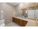 Bathroom with double sinks, wood cabinets, a large mirror, and tile flooring at 1569 Victoria Way, Winter Garden, FL 34787