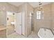 Bathroom featuring tile walls, freestanding tub, walk-in shower, and view into the bedroom at 1569 Victoria Way, Winter Garden, FL 34787