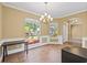 Cozy dining area with stylish light fixture, wainscoting, and large windows providing natural light at 1569 Victoria Way, Winter Garden, FL 34787