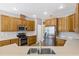 Well-lit kitchen featuring wooden cabinetry, stainless steel appliances, and neutral countertops at 1569 Victoria Way, Winter Garden, FL 34787