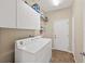 Functional laundry room with a washer, dryer, storage cabinets and utility sink at 1569 Victoria Way, Winter Garden, FL 34787
