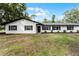 Newly renovated ranch home with white brick exterior, black windows, and well-manicured lawn at 200 Florida Ave, Geneva, FL 32732