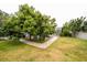 The backyard boasts lush greenery, mature shade trees, and a brick walkway leading to a screened-in lanai at 2225 Kettle Dr, Orlando, FL 32835