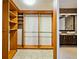 A spacious walk-in closet with custom wood shelving and hanging rods connects to the bathroom at 2225 Kettle Dr, Orlando, FL 32835
