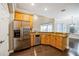 Bright kitchen featuring wood cabinets, granite countertops, stainless steel appliances, and hardwood floors at 2225 Kettle Dr, Orlando, FL 32835