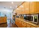 Bright kitchen featuring wood cabinets, granite countertops, stainless steel appliances, and hardwood floors at 2225 Kettle Dr, Orlando, FL 32835