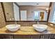 Close-up of bathroom vanity area featuring mosaic tiles, dual sinks, and a large mirror at 2225 Kettle Dr, Orlando, FL 32835