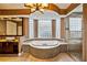 Luxurious bathroom features a unique light fixture, a soaking tub, and a glass-walled shower at 2225 Kettle Dr, Orlando, FL 32835