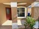 Covered front porch with tile flooring and a red front door at 2267 Santa Lucia St, Kissimmee, FL 34743