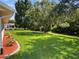 Landscaped backyard, showcasing a lush lawn and mature trees at 26608 Racquet Cir, Leesburg, FL 34748