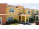 Bright yellow two-story house with a covered entryway and well-manicured landscaping at 3045 Beach Palm Ave, Kissimmee, FL 34747