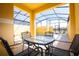 Screened patio area with a table, chairs and pool access at 3045 Beach Palm Ave, Kissimmee, FL 34747