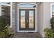 Double front doors with glass insets and a brick walkway at 310 Lake Mariana Pl, Auburndale, FL 33823