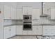 Modern white kitchen with granite countertops and stainless steel appliances at 310 Lake Mariana Pl, Auburndale, FL 33823