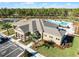 Beautiful clubhouse featuring a sparkling pool, playground, tennis court, and palm trees at 3215 Arch Ave, Ormond Beach, FL 32174