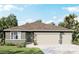 Single-story home with three-car garage and brown roof at 3221 Arch Ave, Ormond Beach, FL 32174