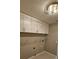 Bright laundry room with ample storage cabinets and shelving at 32712 Timberwood Dr, Leesburg, FL 34748