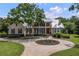 Two-story house with metal roof, circular driveway, and landscaped lawn at 3413 Lilas Ct, Windermere, FL 34786