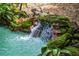 Serene waterfall feature with lush moss and rocks at 3413 Lilas Ct, Windermere, FL 34786
