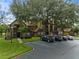 Two-story condo building with parking and large tree at 420 Forestway Cir # 306, Altamonte Springs, FL 32701