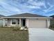 New single-story home with light beige exterior, two-car garage, and well-manicured landscaping at 4306 Sagfefield, St Cloud, FL 34773