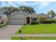 One-story house with a gray exterior, attached garage, and well-maintained lawn at 5405 Justine Way, Winter Park, FL 32792