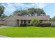 Landscaped one story house with gray siding, attached garage, and spacious yard at 5405 Justine Way, Winter Park, FL 32792