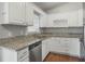 Updated kitchen featuring white cabinets, granite countertops, and stainless steel appliances at 5405 Justine Way, Winter Park, FL 32792