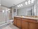 Double vanity bathroom with granite countertops and a large shower at 8876 Candy Palm Rd, Kissimmee, FL 34747