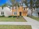 Two-story house with orange exterior, landscaping, and driveway at 8876 Candy Palm Rd, Kissimmee, FL 34747