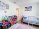 bedroom with a crib, toys, and colorful wall art at 933 El Lago Ter, Winter Springs, FL 32708