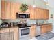 Kitchen with wood cabinets, stainless steel appliances, and a microwave at 933 El Lago Ter, Winter Springs, FL 32708