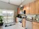 Kitchen features wood cabinets, stainless steel appliances, and sliding door to backyard at 933 El Lago Ter, Winter Springs, FL 32708