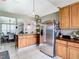 Kitchen features wood cabinets, stainless steel appliances, and view to dining area at 933 El Lago Ter, Winter Springs, FL 32708
