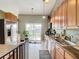 Kitchen with stainless steel appliances, wood cabinets, and backyard access at 933 El Lago Ter, Winter Springs, FL 32708