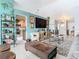 Open living room with a view into the kitchen and a large TV at 933 El Lago Ter, Winter Springs, FL 32708