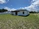 Spacious backyard with green grass and a covered patio area, perfect for outdoor entertaining at 105 Marion Oaks Manor, Ocala, FL 34473