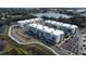 Aerial view of a modern apartment community with ample parking and a lake at 1230 Southstation Pl # 105, Orlando, FL 32809
