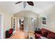 Gathering room with red couch, ceiling fan, and view of dining area at 1309 Paradise Ln, Winter Park, FL 32792