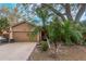 Tan house with a two-car garage and mature landscaping at 1309 Paradise Ln, Winter Park, FL 32792